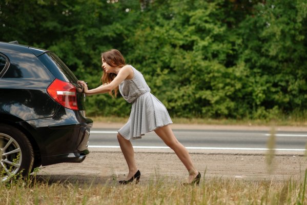 extended car warranty guide woman pushing car on the road